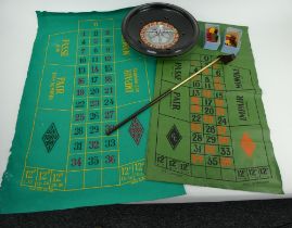 A vintage K&C roulette wheel with two table mats, chips, ball and croupier's rake. 31cm diameter