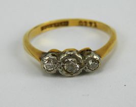 A diamond three stone ring, illusion set, band marked 18ct & PLAT and G271,