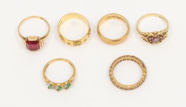 A collection of gold rings to include a 18ct gold band with engraved/embossed decoration, width