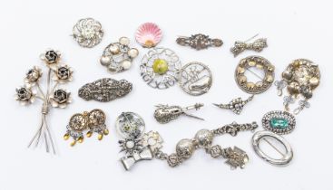 A collection of silver and white metal vintage brooches, including a Sterling 'Craft' floral