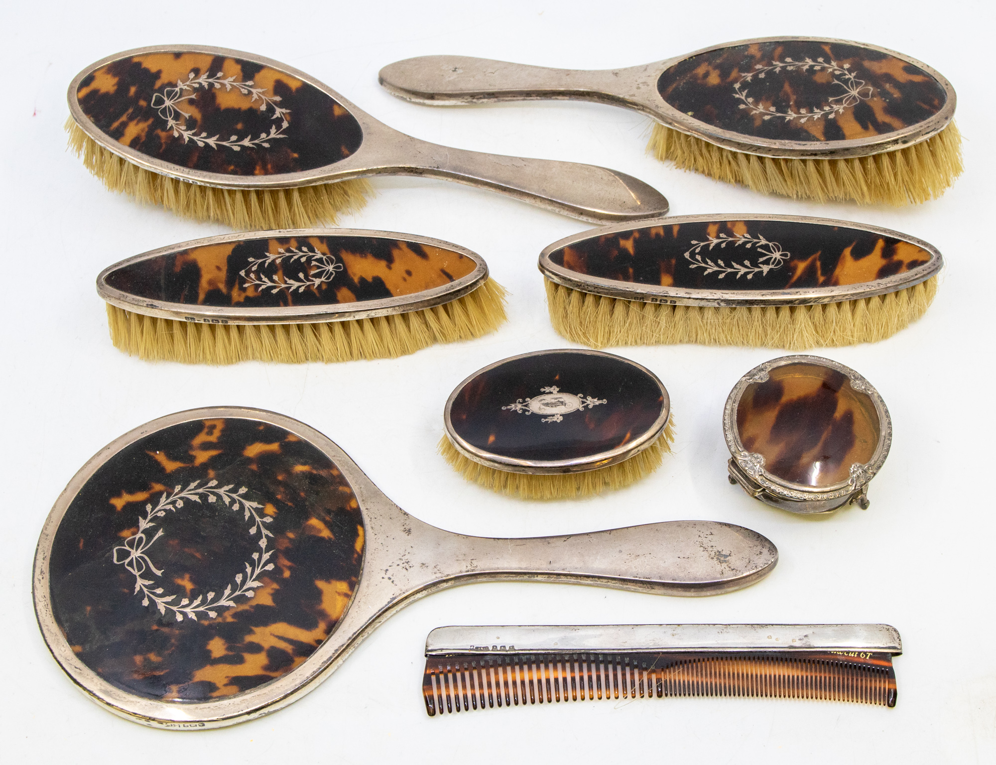 A matching George V silver and faux tortoiseshell dressing table set consisting of hand mirror,