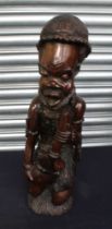 Large African hardwood figure of a native kneeling playing an instrument.