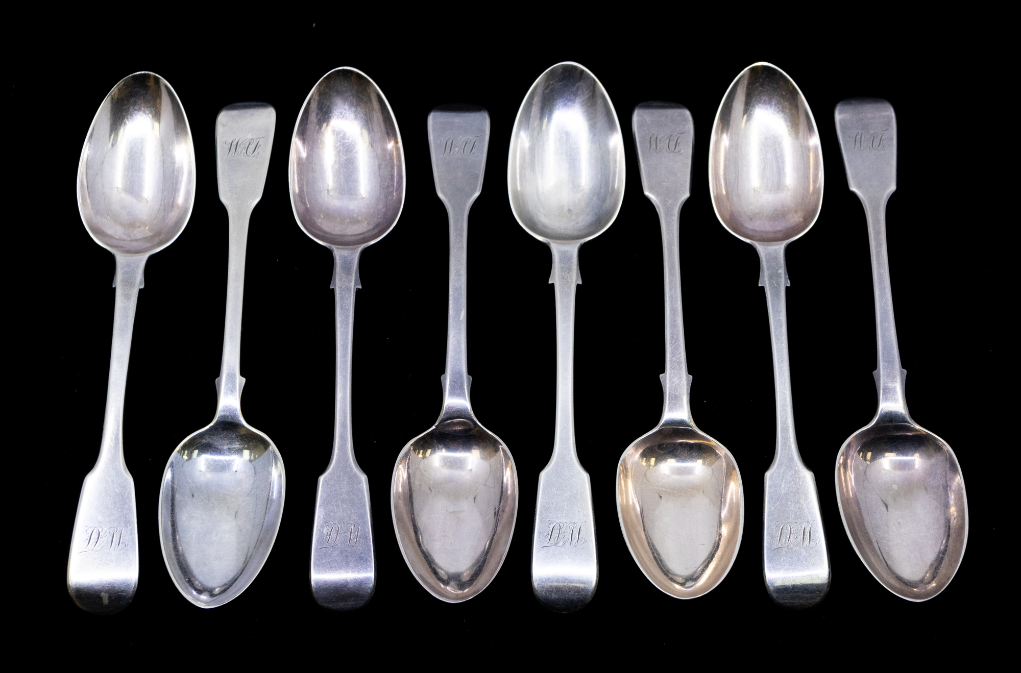 A matched collection of eight late William IV or Victorian fiddle patterned dessert spoons, all