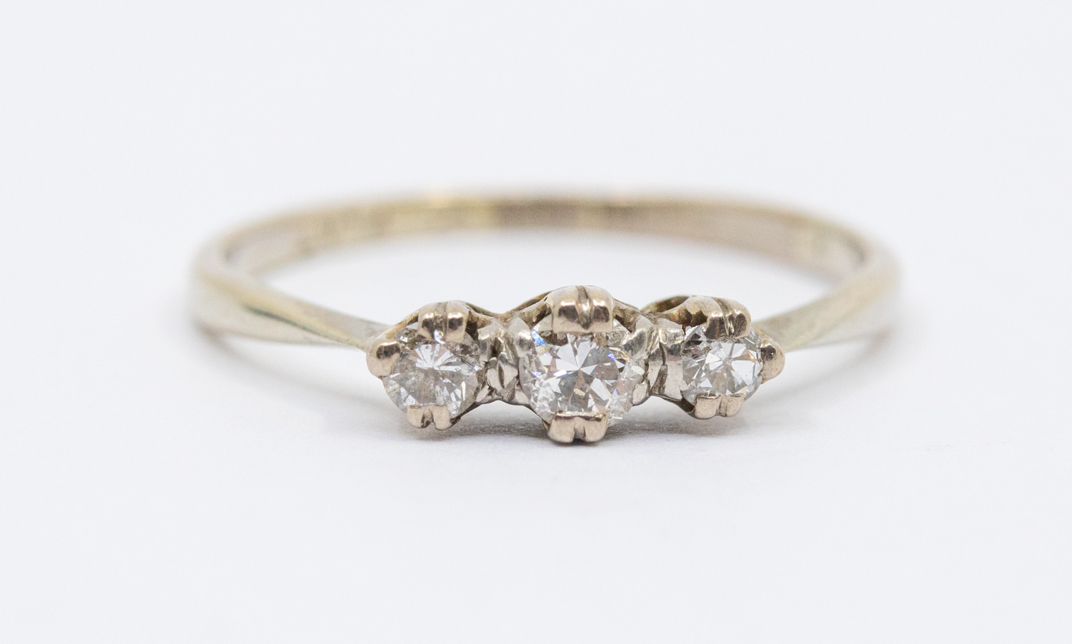 A diamond three stone platinum ring, comprising three graduated diamonds, claw set, total diamond