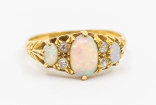 An early 20th century opal and diamond 18ct gold ring, comprising three oval opals, the largest to