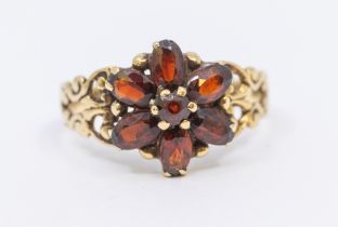 A garnet set 9ct gold cluster ring, comprising a flower head setting, of oval mixed cut stones,