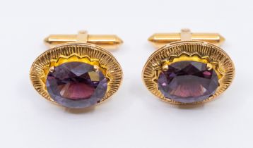 A pair of Chinese 22ct gold cufflinks set with synthetic alexandrite/sapphires, comprising an oval