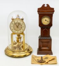 An early 20th century dome brass anniversary clock along with a mahogany clock in the shape of