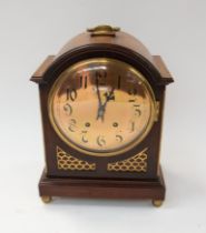 A 19th century mahogany 8-day mantel clock with round brass face, Arabic numerals and chime. There