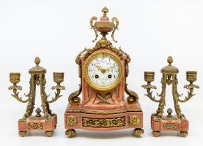 A late 19th/early 20th century clock garniture consisting of red onyx/marble stoned clock with