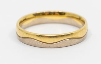 A two tone 18ct gold band, comprising a wave design of white and yellow gold, width approx 4mm, size