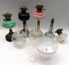 A collection of four late 19th/early 20th century oil lamps to include; a green glass and brass