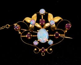 An Edwardian opal and ruby set 18ct gold brooch, comprising an open wire work form with gold