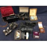 Collection of vintage cameras in cases. Early 20th century racing binoculars, gas masks and razors