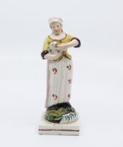 A Staffordshire figure of a girl feeding a cat standing on a square base, c.1825, size 16cm high,