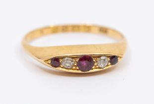 An early 20th century ruby and diamond 18ct gold boat head ring, set with three round mixed cut