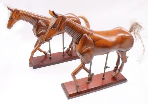 A pair of modern reproduction mechanical wooden horse models, both having movable legs,