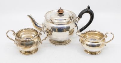A George V silver three piece tea set, plain bodies with egg-and-dart border, ebonised handle and