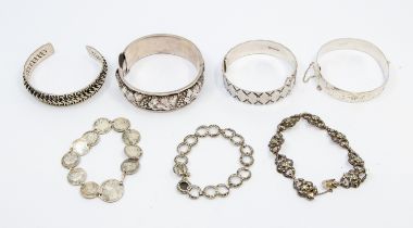 A collection of silver and white metal bangles and bracelets, to include a silver hinged bangle with