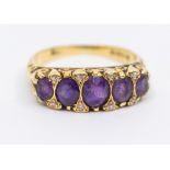 An amethyst and diamond 18ct gold ring, comprising five oval mixed cut graduated amethysts, inset