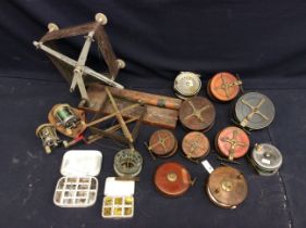 Collection of vintage wooden and metal fishing reels, along with canvass rod holder and rods and a