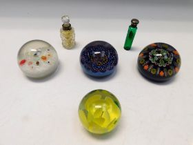 Four early to mid 20th century glass paperweight's and two late 19th century perfume bottles.