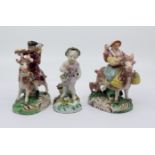 A pair of 20th century Samson figures of The Welch Tailor and Wife, sitting astride goats, base