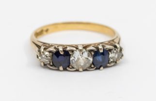 A diamond and sapphire five stone 18ct gold ring, comprising a central old European cut diamond, set