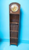 An early 20th Century grandmother clock with book shelves combined, with Charles Dickens