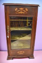 A music cabinet with inlaid Art Nouveau design, four velvet covered helves and glass panelled