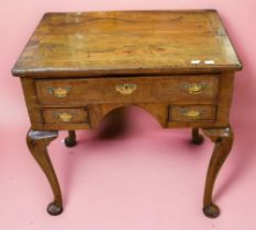 An early 18th century walnut veneered lowboy on cabriole legs, top drawer above two small side by