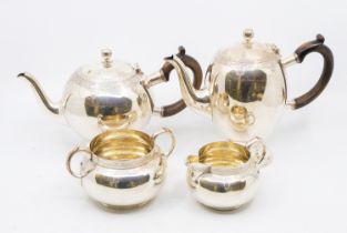 A matched late Victorian silver tea set consisting of a footed tea pot with wooden handle, a