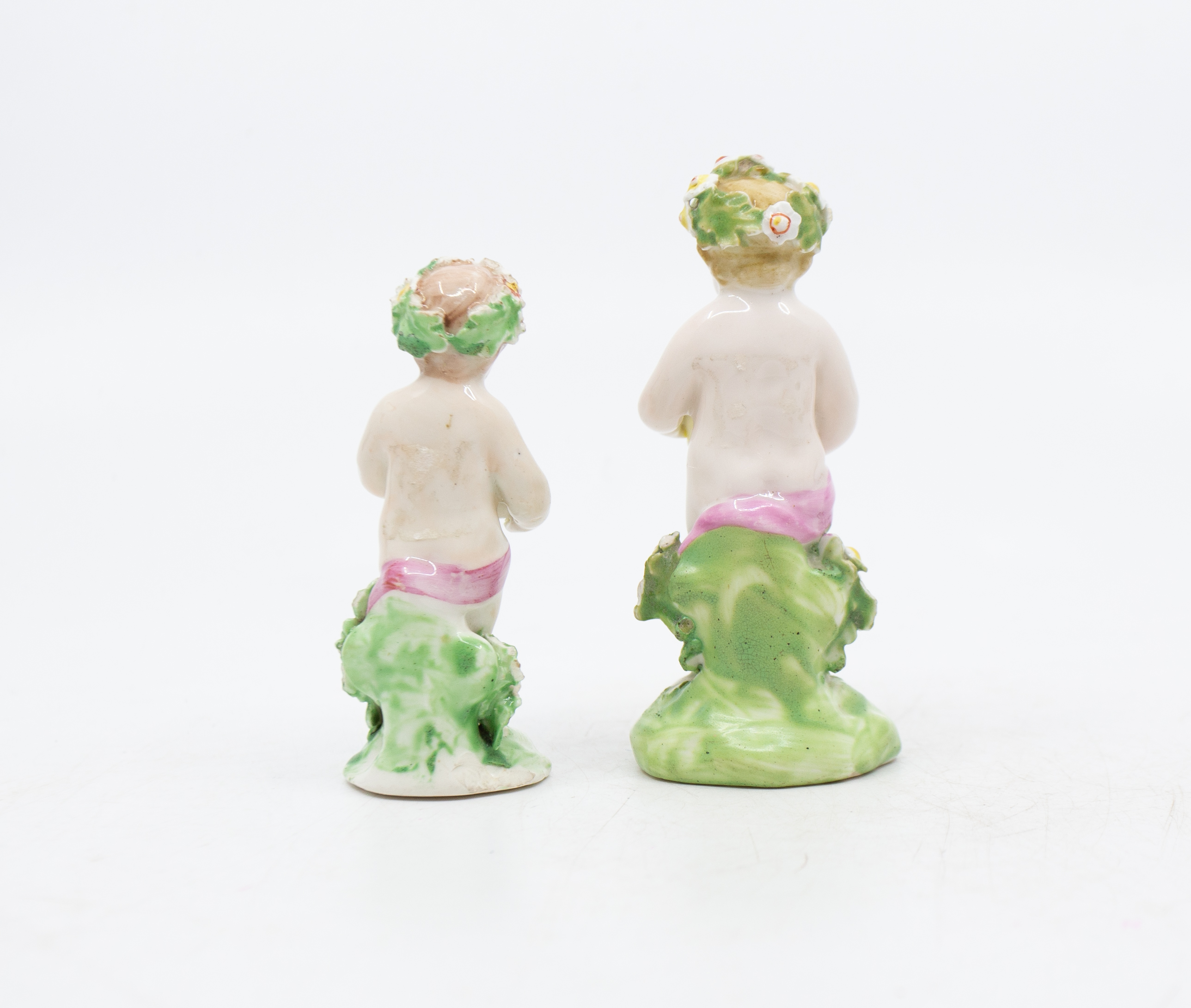 Two late 18th century porcelain putti holding bouquets of flowers, with patch marks to base. Good - Image 2 of 3