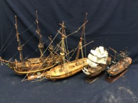 Four handmade and kit model boats on stands