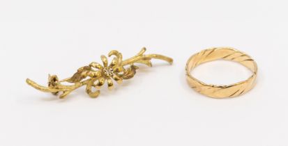 A 9ct gold diamond set brooch, with branch like decoration, overlaid with a flower set with a