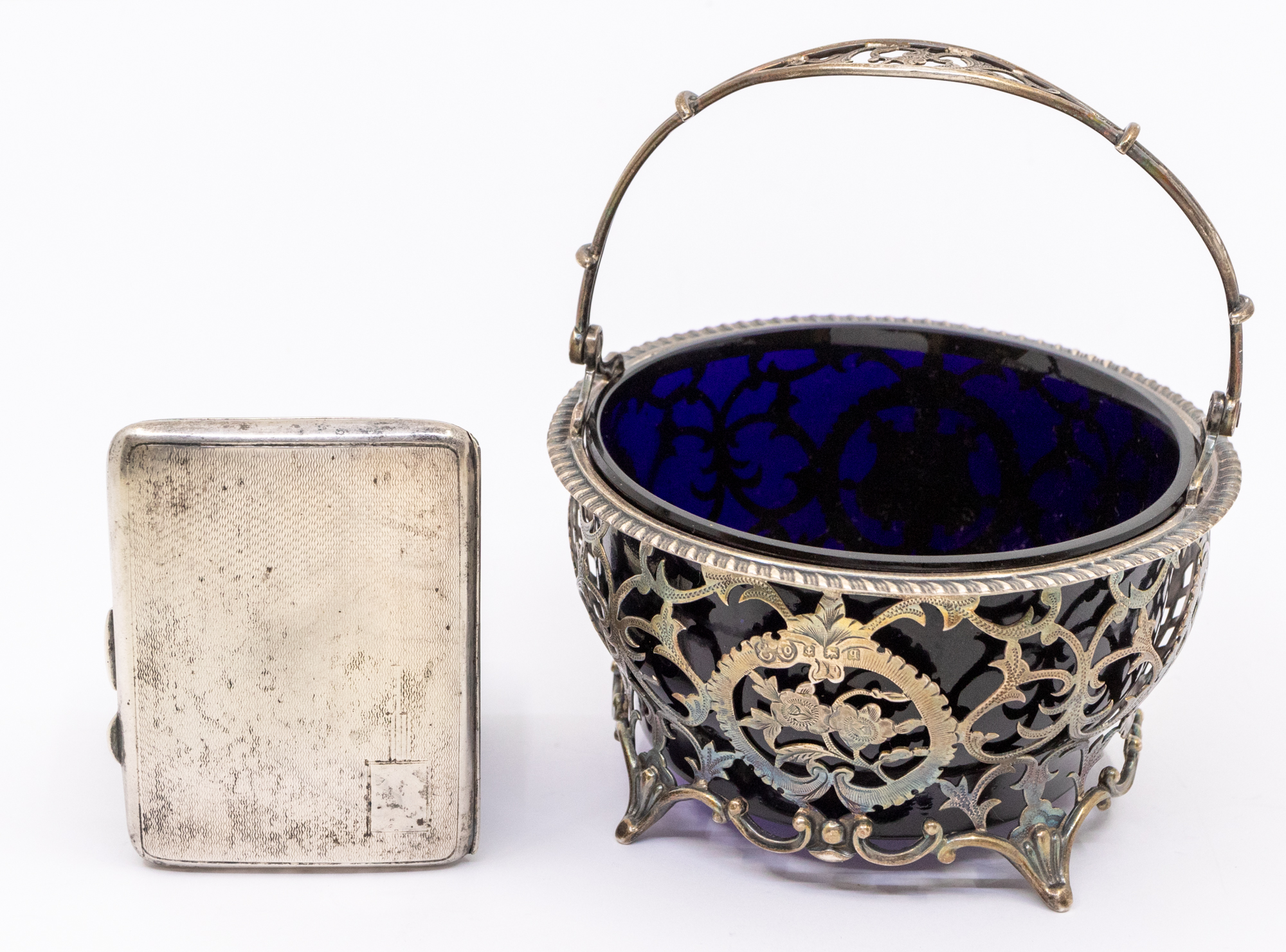 A George V pierced silver sugar basket, single looping handle and four splayed feet, of stylised