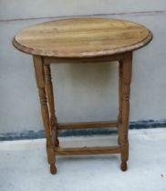 An early 20th occasional oval side table on turned legs.