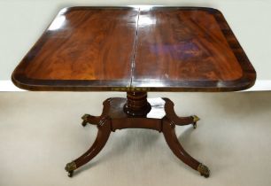 A 19th century mahogany and rosewood fold over tea table with turned support and four splayed legs