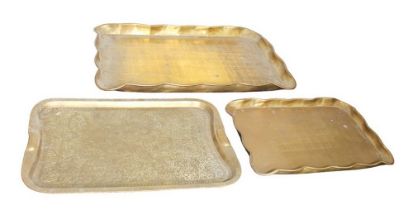 A collection of brass and treen serving trays to include Indian carved.