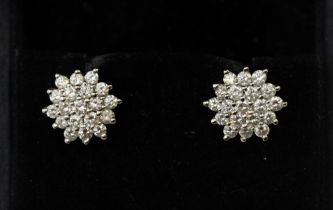 A pair of diamond set 18ct gold cluster earrings, comprising a flower design, claw set with round