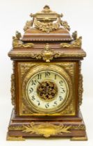 A large late 19th century bracket clock with stylised brass supports and decoration, handle