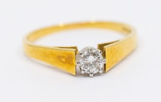 A diamond and 18ct gold ring, comprising a platinum set round brilliant cut diamond, diamond