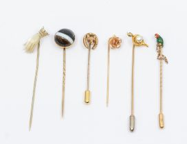 A collection of Victorian and later stick pins to include a gold and enamel parrot cased, (some