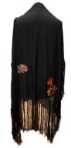 A black silk vintage shawl with vibrant shades of orange and gold floral and foliage, shawl is edged