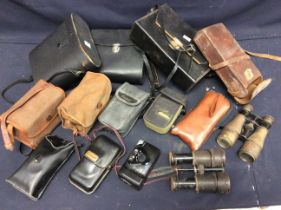 A collection of vintage early to mid 20th century binoculars and cameras including video camera.