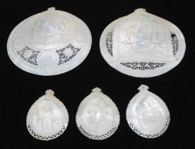 Two carved mother of pearl religious designed clam shells, intricately carved with pierced detail,