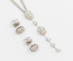 A diamond and 18ct white gold pendant and earrings set, comprising a drop of two domed oval pave set