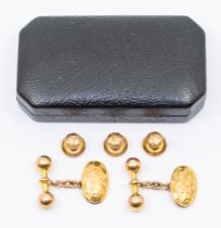 A pair of 9ct gold cufflinks, comprising an oval foliate engraved form with a dumbbell bar link,