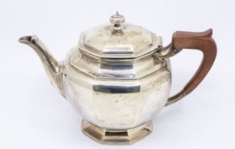 A Queen Elizabeth II silver tea pot, of octagonal shape with footed base and wooden handle.