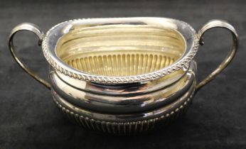 A twin handled partly fluted oval silver sugar bowl